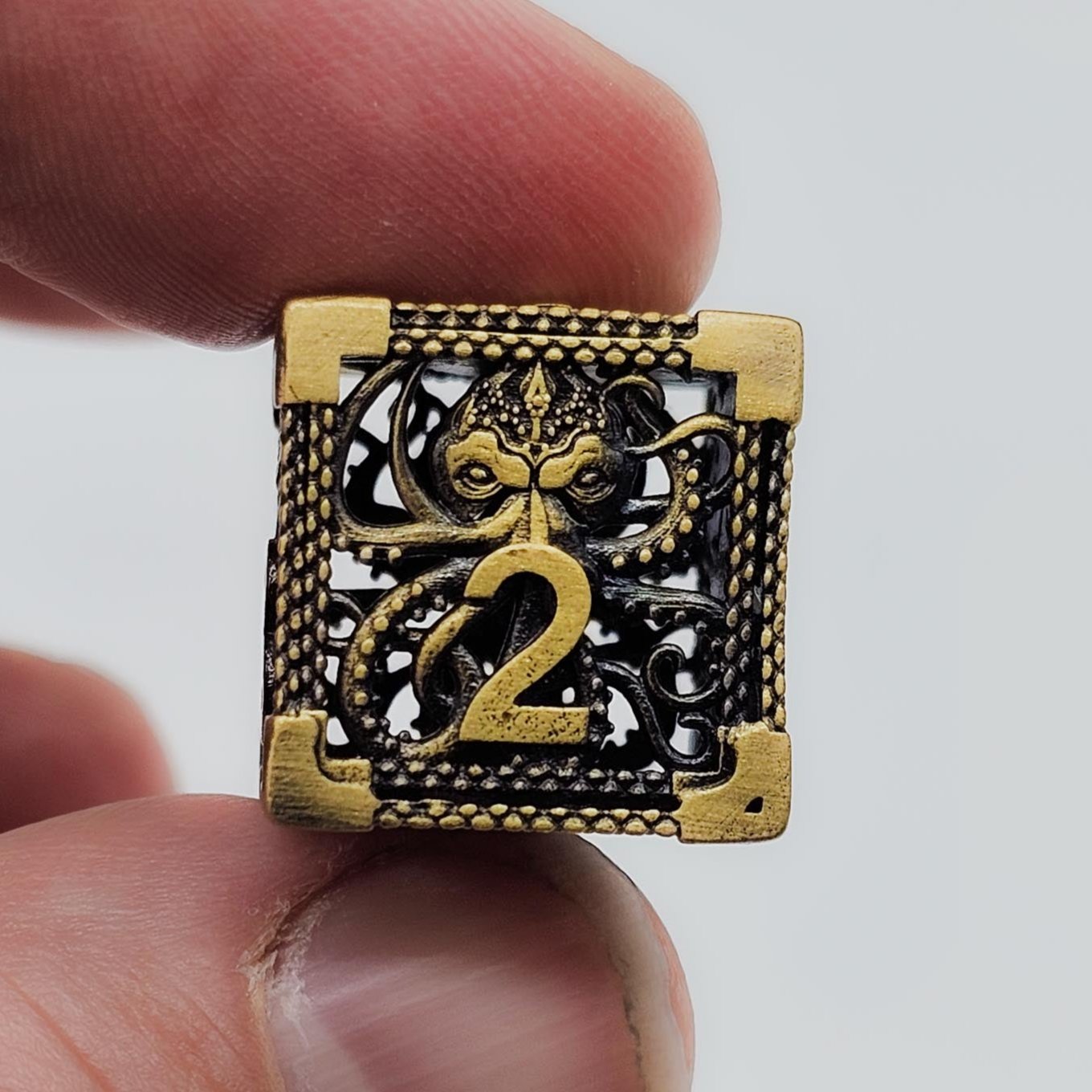 Close up of theAncient Gold Hollow Metal Cthulhu DND Dice Set