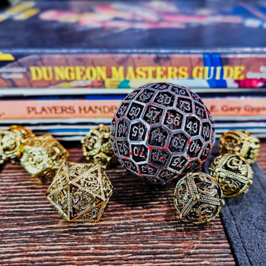 Hollow Metal Silver Blood D100 DND Dice surrounded by shiny gold hollow dice with a Dungeon Masters Guide and Dungeons and Dragons Player Handbook stacked up behind.
