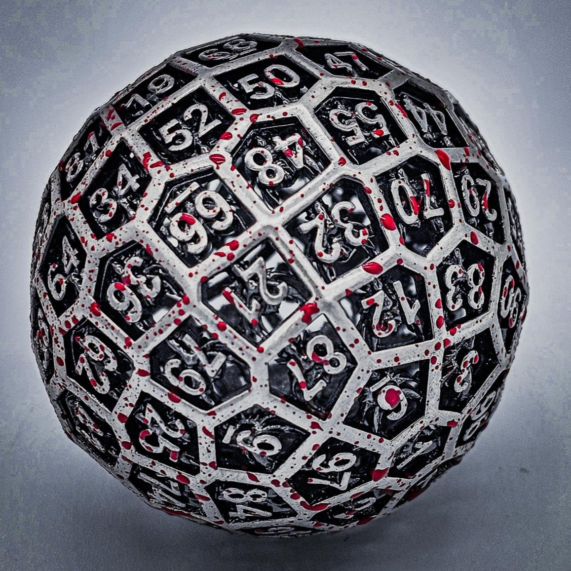 close up shot of a Hollow Metal Silver Blood D100 DND Dice