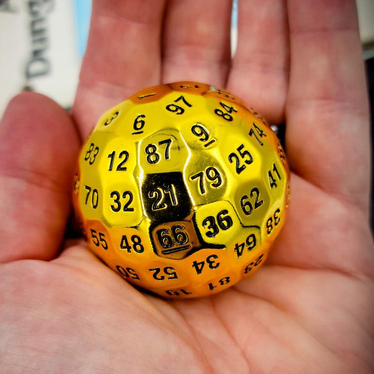 Metal Shiny Gold D100 DND Dice in the palm of a persons hand showing how large it is.