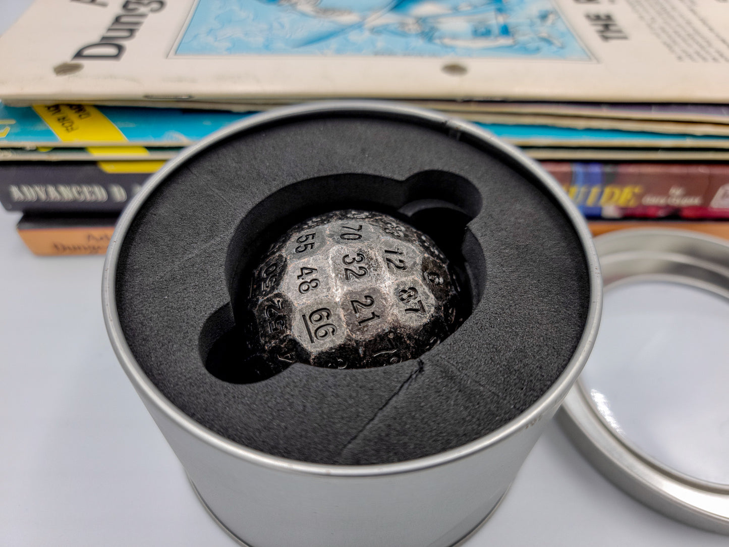 Metal Silver D100 DND Dice inside a silver metal continer with the lid off and is contained by large foam inside.
