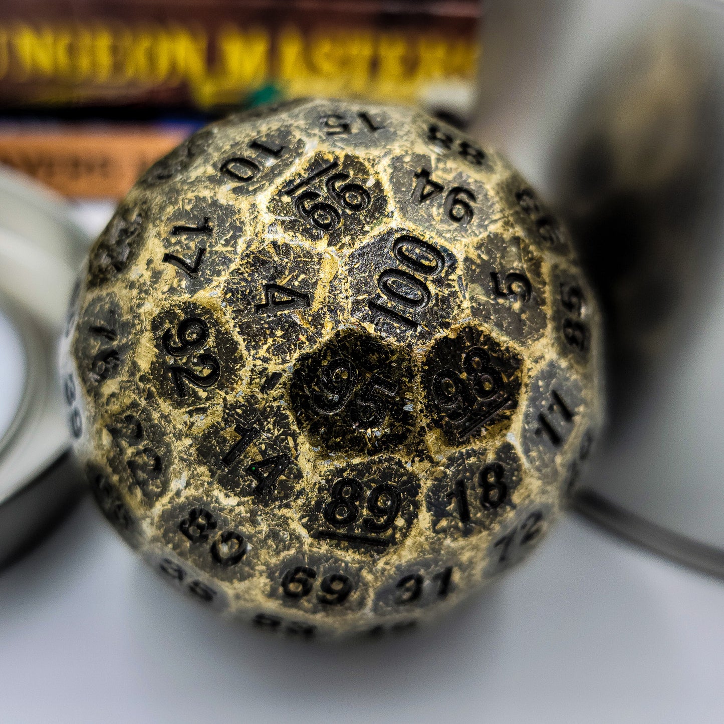 Solid Metal Antique Gold D100 DND Dice close up shot