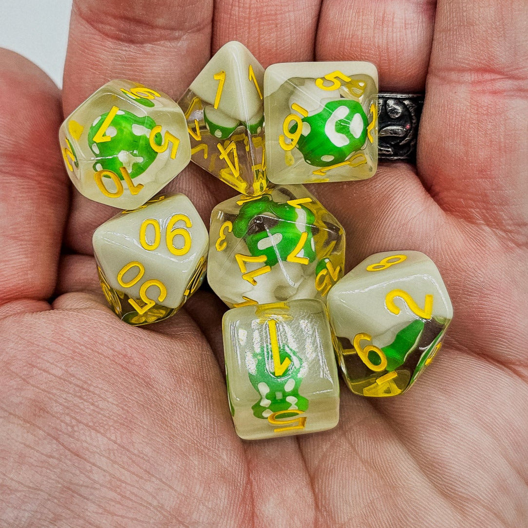 Transparent resin DND dice with Green mushrooms inside laying in the palm of someone's hand