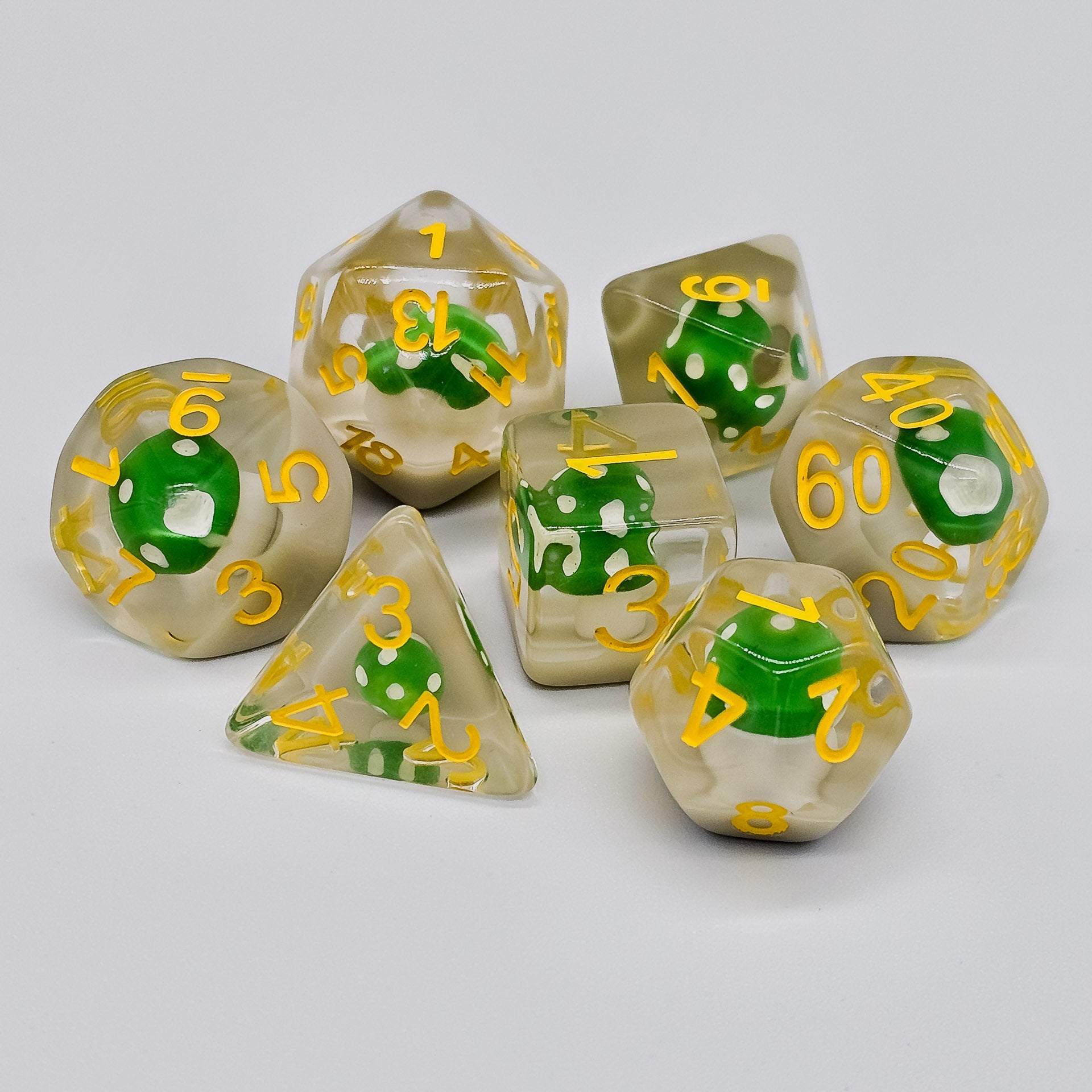 Transparent resin DND Dice with green mushrooms inside scattered on a white canvas.