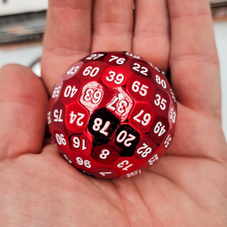 Red Solid Metal D100 DND Dice in the palm of a person hand.