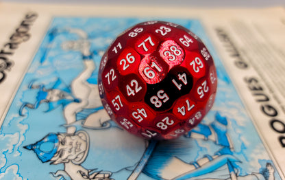 a Red Solid Metal D100 DND Dice on top of a blue dungeons and dragons manual.