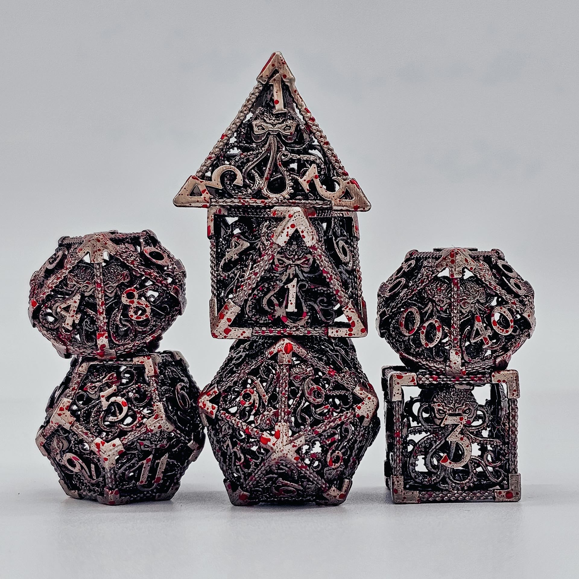 Silver with blood spatters hollow metal DND dice with cthulhu etches theme.