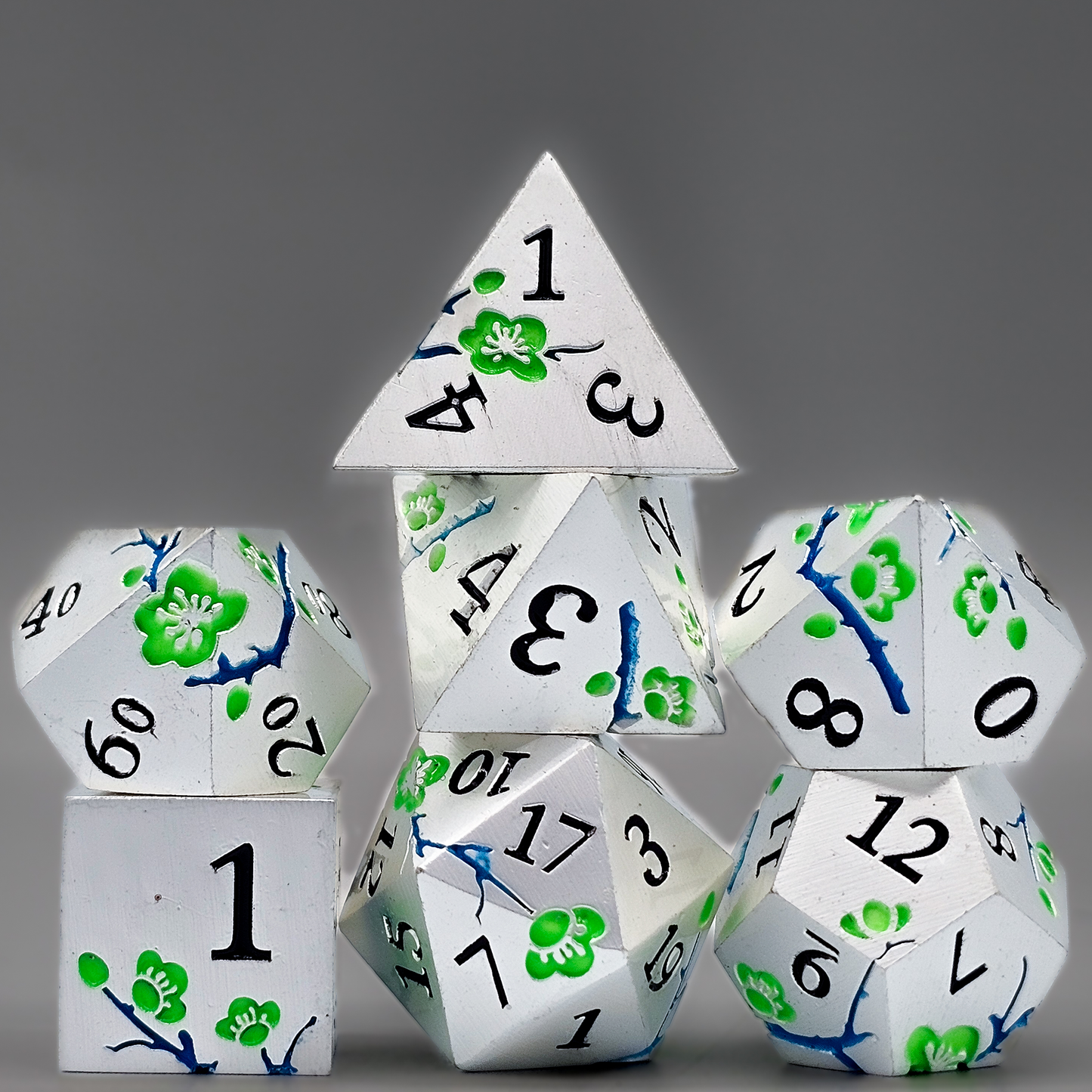 Silver solid metal DND Dice with green japanese plum blossoms and blue twigs etched into the sides